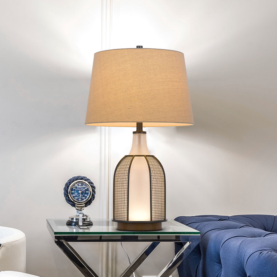 Ceramic table lamp with drum shade in a living room setting